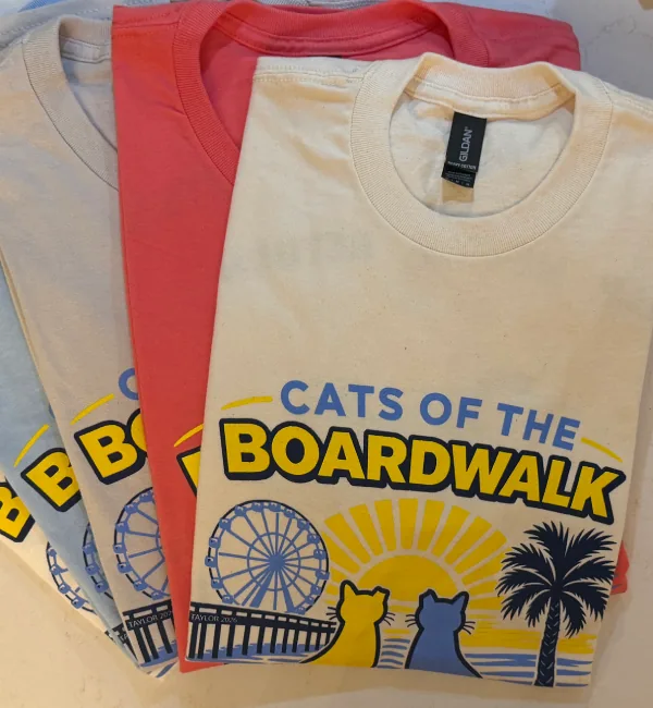 Full-color Cats of the Boardwalk design shown on several shirt colors.